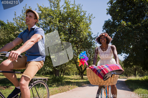 Image of Young multiethnic couple having a bike ride in nature