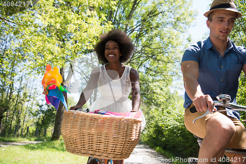 Image of Young multiethnic couple having a bike ride in nature