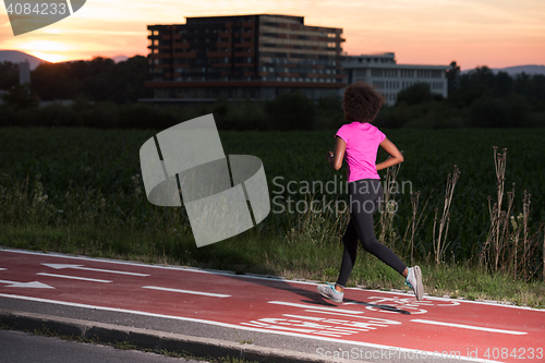 Image of a young African American woman jogging outdoors