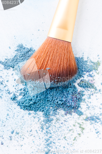 Image of Blank background with crumbled eye shadows and brush