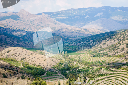 Image of Views of hilly landscape with mountains and blue cloudy sky