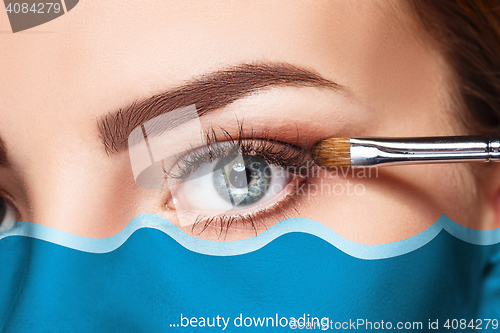 Image of Beautiful female eyes with make-up and brush