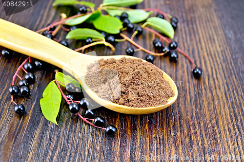 Image of Flour bird cherry in spoon with berries on dark board