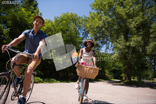 Image of Young multiethnic couple having a bike ride in nature
