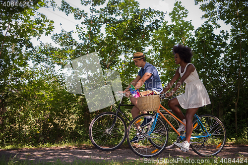 Image of Young multiethnic couple having a bike ride in nature