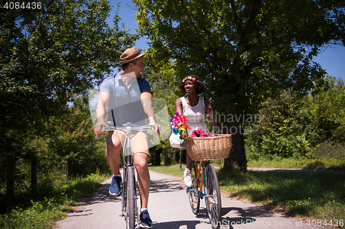 Image of Young multiethnic couple having a bike ride in nature