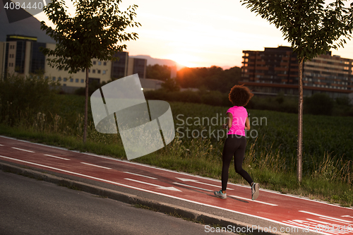 Image of a young African American woman jogging outdoors