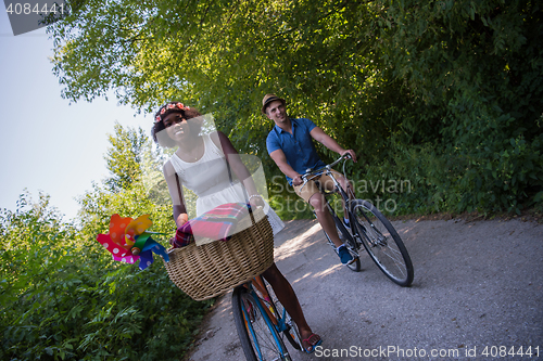 Image of Young multiethnic couple having a bike ride in nature