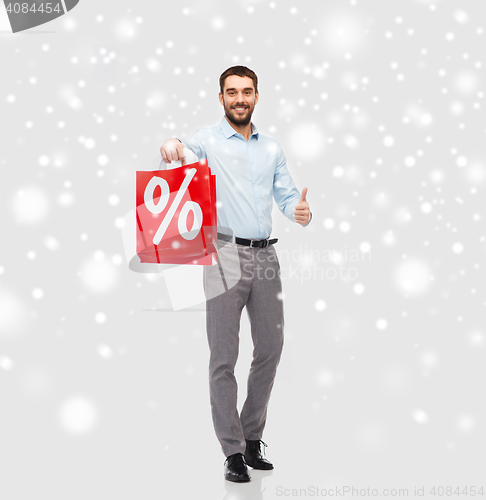 Image of happy man with red shopping bag showing thumbs up