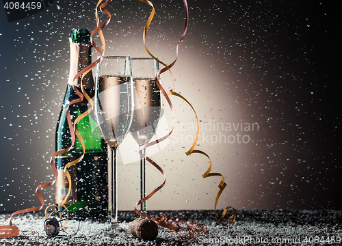 Image of Bottle of champagne and filled glasses, festive composition with decoration