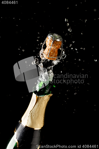 Image of Bottle of champagne exploding isolated on black background