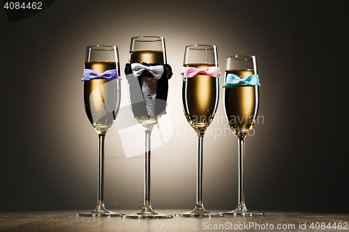 Image of Glasses of champagne dressed in wedding suit and bow tie