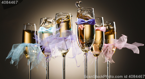 Image of Glasses with champagne dressed in tie bows and veil