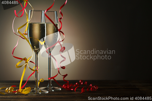 Image of Two champagne glasses decorated with gold and red bow