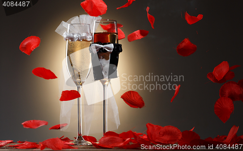 Image of Beautiful decorated champagne glasses for newlyweds with red rose petals