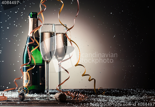 Image of Bottle of champagne and filled glasses decorated in festive theme