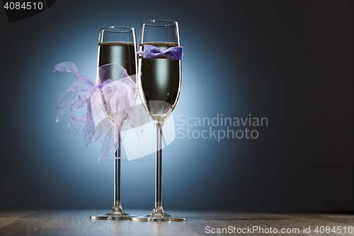 Image of Champagne glasses decorated purple bow-tie and veil for honeymooners