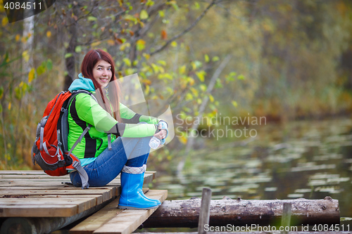 Image of Young girl with long hair and backpack tourist