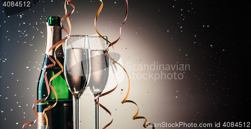 Image of Bottle of champagne and two filled glasses, holiday concept