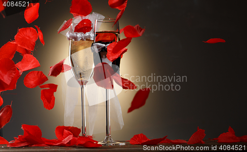 Image of Elegant champagne glasses for bride and groom with rose petals