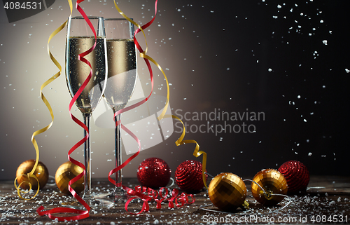 Image of Glasses of sparkling champagne with Christmas decorations and snowflakes