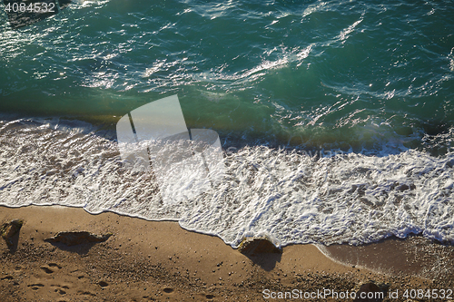 Image of Soft waves and sea foam on sandy beach