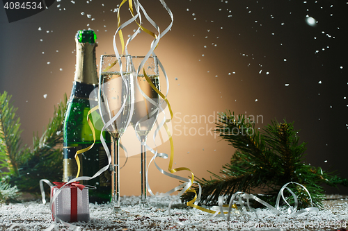 Image of Festive Christmas composition with champagne glasses, gift and snow