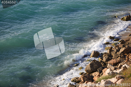 Image of Wild beach with rocky shore and pure black sea