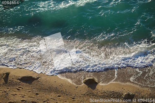 Image of Transparent turquoise waves lapping on the sand