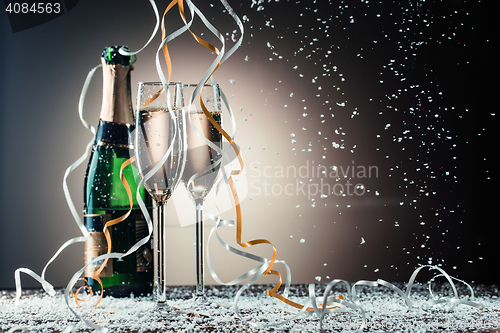 Image of Bottle of champagne and wine glasses with ribbons