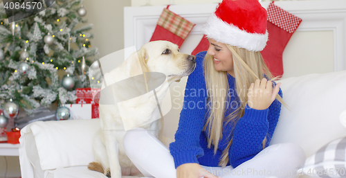 Image of Christmas girl with her dog friend at the couch