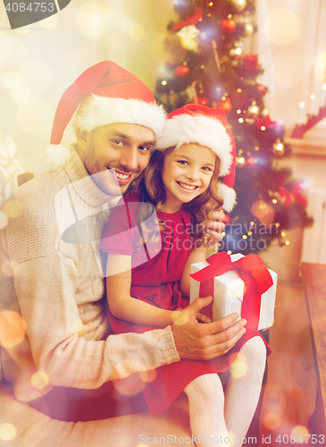 Image of smiling father and daughter holding gift box