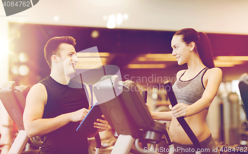 Image of woman with trainer exercising on stepper in gym