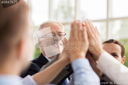 Image of business people making high five in office