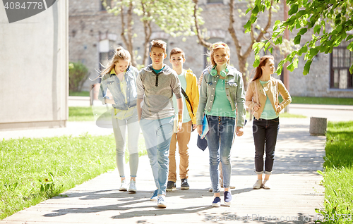 Image of group of happy teenage students walking outdoors