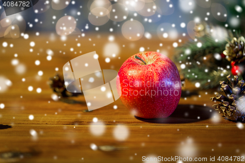 Image of close up of apple with fir decoration on wood