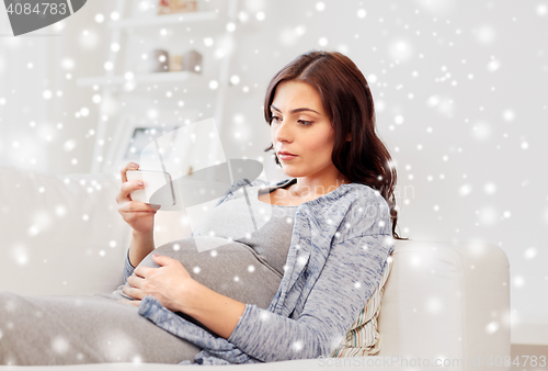 Image of sad pregnant woman with smartphone at home
