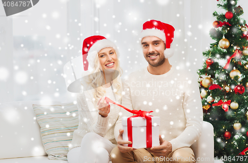 Image of happy couple at home with christmas gift box