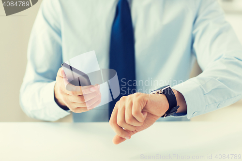 Image of close up of hands with smart phone and watch