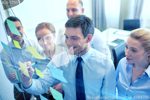 Image of smiling business people with marker and stickers