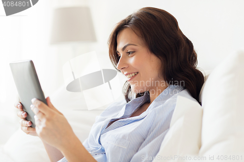 Image of smiling woman with tablet pc at home