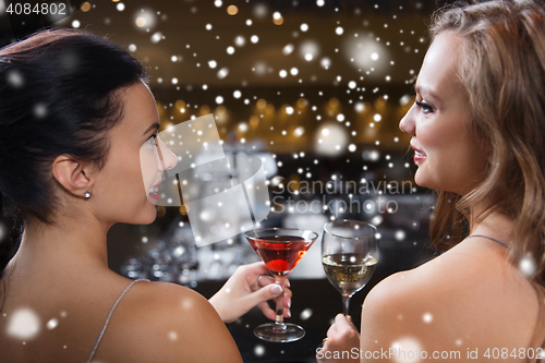 Image of happy women with drinks at night club bar