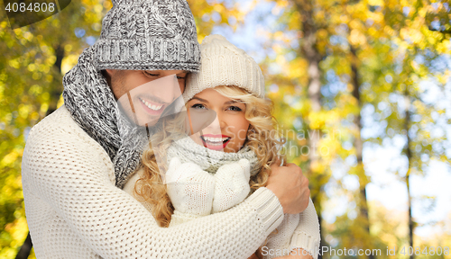 Image of happy couple in warm clothes over autumn