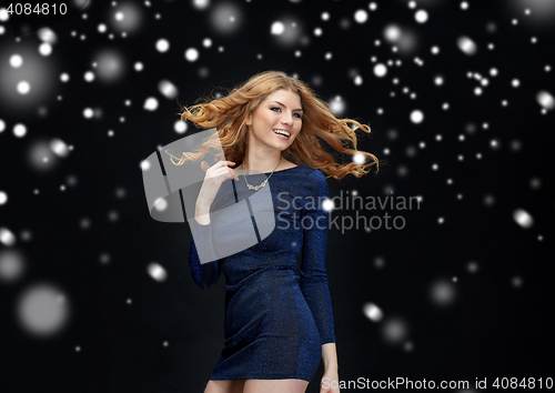 Image of happy young woman dancing over snow