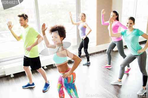 Image of group of smiling people dancing in gym or studio