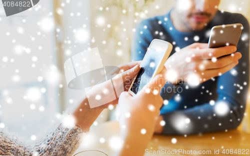 Image of close up of couple with smartphones at cafe