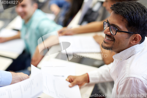 Image of happy student with exam test or handout at lecture