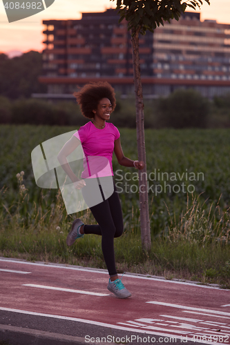 Image of a young African American woman jogging outdoors