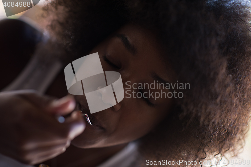 Image of a young African American woman eating pasta