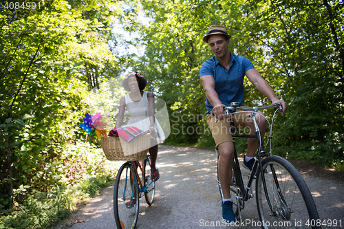 Image of Young multiethnic couple having a bike ride in nature